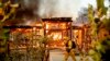 Woodbridge firefighter Joe Zurilgen passes a burning home as the Kincade Fire rages in Healdsburg, California, Oct 27, 2019. 