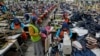 FILE - Workers sit in their stations at factory in Bandung, West Java province, Indonesia, July 11, 2024. The ILO says the global labor income share had fallen by 1.6 percentage points since 2004.