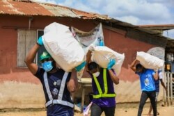 FILE - Volunteers carry sacks filled with food to distribute to vulnerable residents, during a lockdown by the authorities in efforts to limit the spread of the coronavirus disease (COVID-19), in Lagos, Nigeria, April 9, 2020.