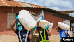 FILE - Volunteers carry sacks filled with food to distribute to vulnerable residents, during a lockdown by the authorities in efforts to limit the spread of the coronavirus disease (COVID-19), in Lagos, Nigeria, April 9, 2020. 