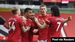 Manchester United team members celebrate scoring their second goal in their match against Burnley-Old Trafford, in Manchester, Britain, April 18, 2021.