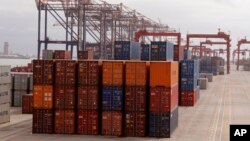 FILE - Goods are stacked in containers destined for global distribution at the harbor in Cape Town, South Africa, June 24, 2016. 