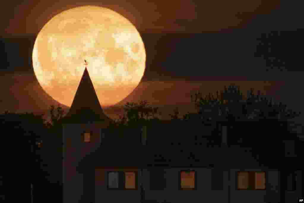 La luna lleva se eleva sobre una vivienda en la localidad de Putilovo, a 70 kilómetros (43 millas) al este de San Petersburgo, Rusia, el 13 de julio de 2022.&nbsp;
