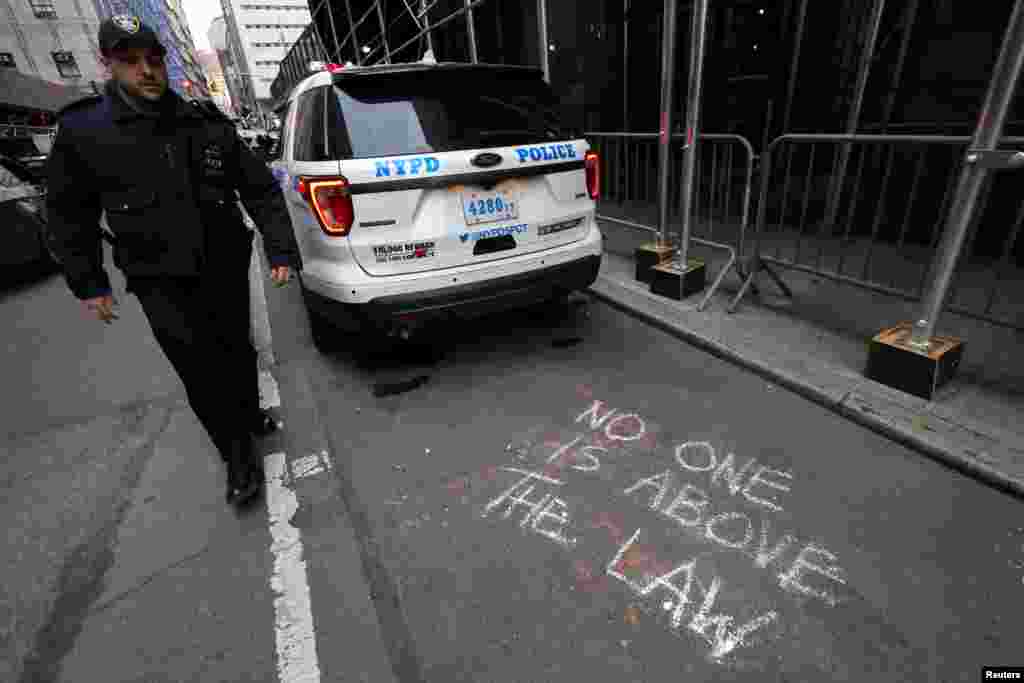 Un grafiti escrito con tiza donde se lee &quot;nadie está por encima de la ley&quot;, en inglés, se ve en una calle frente a las oficinas del fiscal de distrito de Manhattan, el 22 de marzo de 2023, donde un gran jurado decide si presentar cargos criminales contra el expresidente Donald Trump.&nbsp;