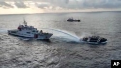 Kapak garda pantai China (kiri) menembakkan meriam air ke arah kapal biro perikanan Filipina di dekat wilayah yang disengketakan di Laut China Selatan, pada 4 Desember 2024. (Foto: National Task Force for the West Philippine Sea via AP)