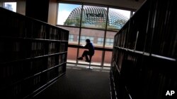 FILE - A man is silhouetted at a library in Singapore. 