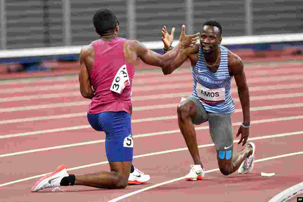 Isaiah Jewett, of the United States, and Nijel Amos, right, of Botswana, shake hands after falling in the men&#39;s 800-meter semifinal at the 2020 Summer Olympics, Sunday, Aug. 1, 2021, in Tokyo. (AP Photo/Jae C. Hong)