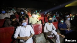 People wear protective masks while watching a movie at a cinema in Peshawar after Pakistan lifted lockdown restrictions, as the coronavirus disease (COVID-19) outbreak continues, Aug. 10, 2020.