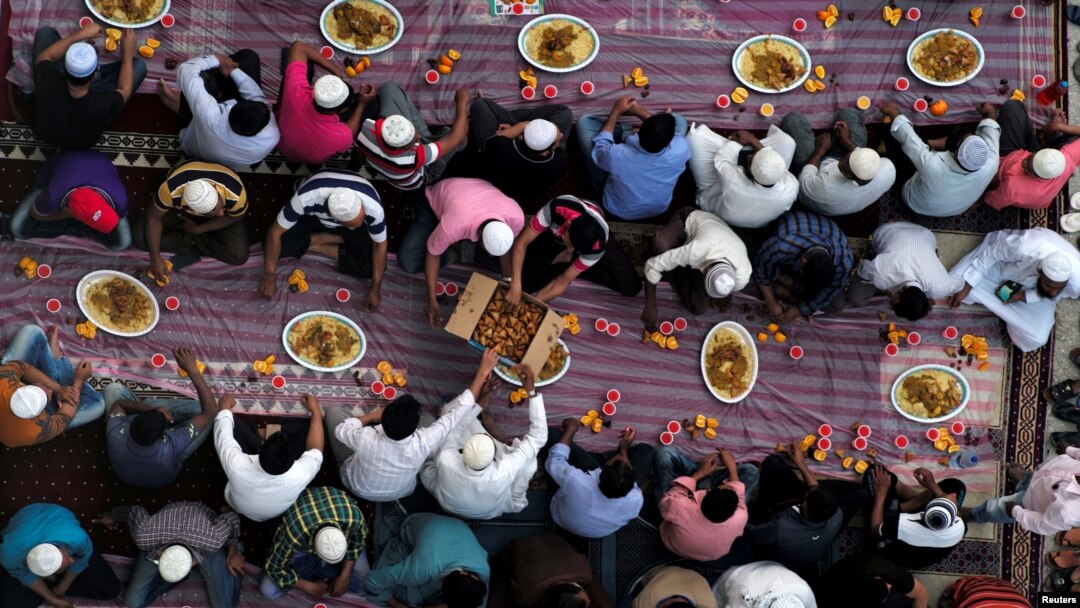 Ilustrasi. Muslim membagikan makanan saat mereka menunggu untuk berbuka puasa di luar masjid selama bulan suci Ramadhan, di Manama, Bahrain. (Foto: Reuters/Hamad I Mohammed)