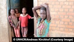 Des enfants déplacés à l’entrée d’un dépôt vide leur servant d’abri au Kasaï, RDC, 8 septembre 2017. © UNHCR/Andreas Kirchhof.