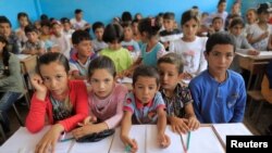 Children attend their first class immediately after they got registered at the school in Hazema North Raqqa, Syria, Aug. 21, 2017. 