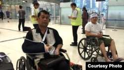 Cambodian opposition​ CNRP lawmakers Nhay Chamroeun (left) and Kong Saphea (right) are seen arriving in wheelchairs at a Bangkok airport on Tuesday, October 27, 2015, after being beaten by protesters in Phnom Penh, Cambodia. (Photo courtesy of Nhay Chamroeun) 