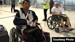 Cambodian opposition​ CNRP lawmakers Nhay Chamroeun (left) and Kong Saphea (right) are seen arriving in wheelchairs at a Bangkok airport on Tuesday, October 27, 2015 after being beaten by protesters in Phnom Penh, Cambodia on Monday. (Courtesy of Nhay Cha