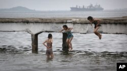 지난 6월 북한 원산 해변의 잔교에서 어린 소녀들이 물 속으로 뛰어들고 있다.