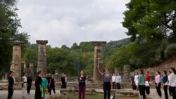 Greek actress Xanthi Georgiou, playing the role of the High Priestess, holds up the torch during the final rehearsal for the lighting of the Olympic flame at Ancient Olympia site.