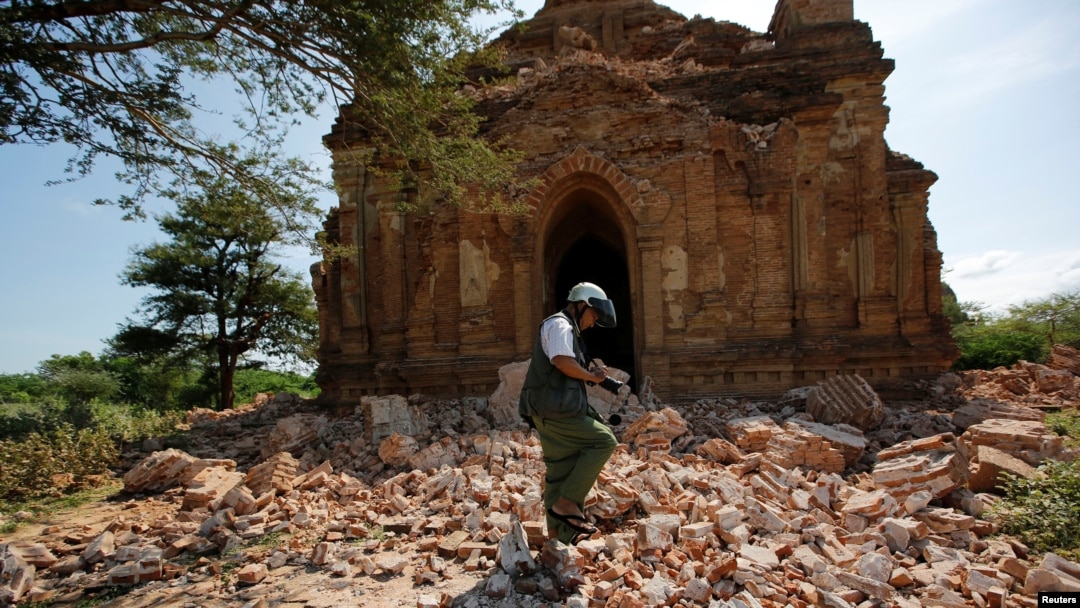 FILE - A photographer walks outside a collapsed pagoda after an earthquake in Bagan, Myanmar, Aug. 25, 2016. 