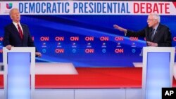 Former Vice President Joe Biden, left, and Sen. Bernie Sanders, I-Vt., right, participate in a Democratic presidential primary debate at CNN Studios in Washington, Sunday, March 15, 2020. 