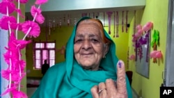 جمعہ، 19 اپریل، 2024، کوجموں و کشمیر کے ضلع ڈوڈا میں بھارت کے قومی انتخابات کے پہلے راؤنڈ کی پولنگ کے دوران ووٹ ڈالنے کے بعد ایک خاتون اپنی انگلی پر انمٹ سیاہی کا نشان دکھا رہی ہیں۔ (اے پی فوٹو)