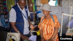 Adelle Mubalama, right, a tailor with a shop at Kenya's Kakuma refugee camp, was able to launch a business when she got a loan from Inkomoto. The organization helps small business entrepreneurs. (Photo courtesy of Inkomoto)