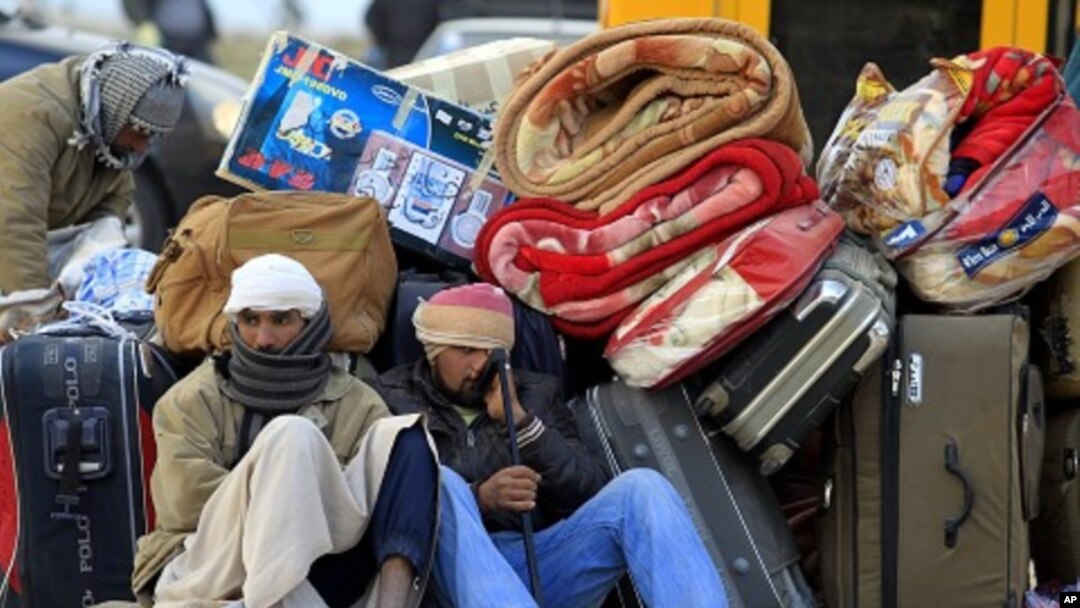 Egyptians sit next to their belongings as they wait for transportation near the Libyan and Tunisian border crossing of Ras Jdir after fleeing unrest in Libya, February 28, 2011