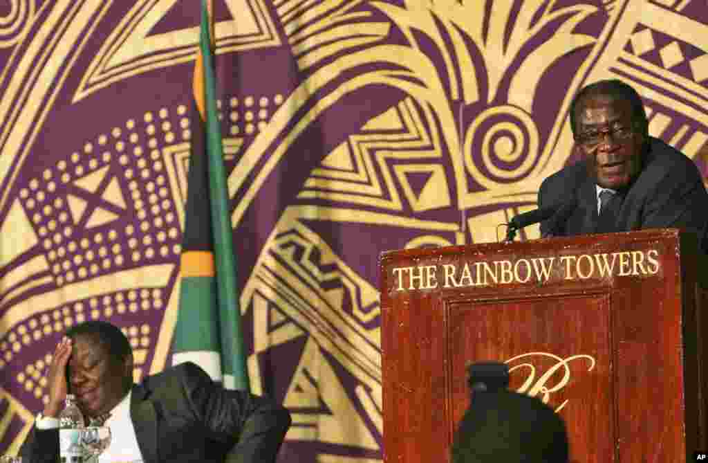 President Robert Mugabe, right, delivers his speech while the new Prime Minster Morgan Tsvangirai, left listens at the signing of the power sharing deal in Harare Monday, Sept, 15, 2008. Thousands of supporters of Zimbabwe&#39;s rival political parties pressed into the compound where their leaders just signed an historic power-sharing deal to cheer the leaders.