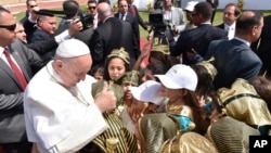 Le pape François salue les enfants habillés en costumes égyptiens anciens avant de célébrer la messe pour la petite communauté catholique égyptienne, au stade de défense aérienne au Caire, Egypte, 29 avril 2017.