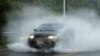 Un automóvil se mueve por una calle parcialmente inundada mientras la tormenta tropical Fay se extiende por el noreste de Estados Unidos en Jersey City, Nueva Jersey. 10 de julio de 2020.