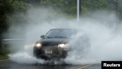 Un automóvil se mueve por una calle parcialmente inundada mientras la tormenta tropical Fay se extiende por el noreste de Estados Unidos en Jersey City, Nueva Jersey. 10 de julio de 2020.