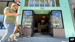 A pedestrian walks his dog by Dogue, a dog restaurant in San Francisco, Sunday Oct. 25, 2022. (AP Photo/Haven Daley)