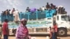 People board a truck as they leave Khartoum, Sudan, on June 19, 2023.