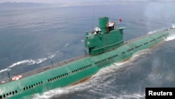 FILE - North Korean leader Kim Jong Un (L) stands on the conning tower of a submarine during his inspection of the Korean People's Army (KPA) Naval Unit 167 in this undated photo released by North Korea's Korean Central News Agency (KCNA) in Pyongyang, June 16, 2014.