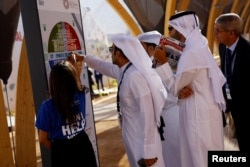 FILE - Participants ask for directions on the first day of the annual meeting of the International Monetary Fund and the World Bank.