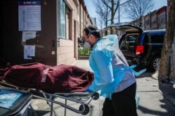Employees deliver a body at Daniel J. Schaefer Funeral Home, on April 2, 2020, in the Brooklyn borough of New York.