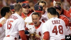 Kolten Wong es felicitado por sus compañeros luego de anotar el jonrón ganador en la novena entrada del juego 2 contra los Gigantes de San Francisco.