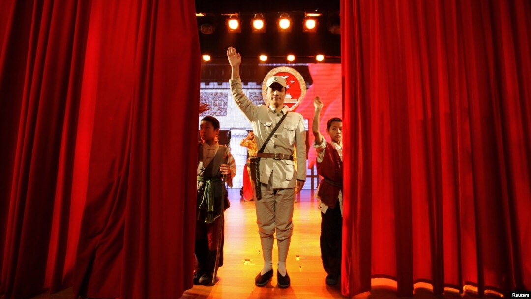 An actor dressed as an Eighth Route Army soldier waves after a performance at the Eighth Route Army Culture Park, one of two theme parks, in Wuxiang county, north China's Shanxi province, October 20, 2012. 