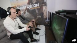 Two players enjoy some quality time with a video game - "Tom Clancy's Ghost Recon Wildlands: War Within the Cartel" - during a livestream event, Feb. 16, 2017, in Los Angeles.