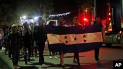 Para migran dari Honduras membawa bendera Honduras saat memulai perjalanan dengan harapan bisa mencapai Amerika Serikat, di Entre Rios, Guatemala, 16 Januari 2020. (Foto: AP)