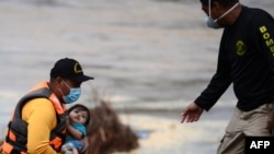 Bomberos rescatan a residentes de campos bananeros inundados tras el paso de la tormenta Eta en el departamento de Yoro, en Honduras, el 7 de noviembre de 2020.