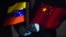 FILE - In this March 30, 2020, photo, Venezuela's Foreign Minister Jorge Arreaza holds Venezuelan and Chinese flags as medical specialists and supplies arrive from China at the Simon Bolivar International Airport in La Guaira, Venezuela.