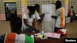 Polling agents count ballots at a polling station during the referendum for a new constitution, in Abidjan, Ivory Coast, Oct. 30, 2016. 