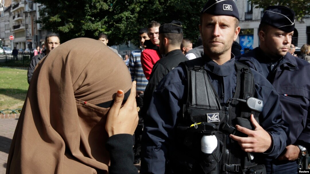 Seorang perempuan yang mengenakan niqab atau cadar menutup wajahnya saat pemeriksaan kartu identitas di kota Lille, Perancis (foto: dok). 