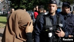 Seorang perempuan yang mengenakan niqab atau cadar menutup wajahnya saat pemeriksaan kartu identitas di kota Lille, Perancis (foto: dok). 