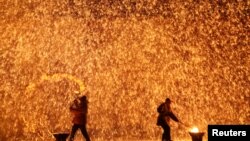 Performers throw molten iron against a wall to create sparks during a traditional performance ahead of the Dragon Boat festival in Zhangjiakou, Hebei province, China May 29, 2017. 