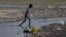 A boy crosses a drain on the banks of the river Ganges in Kanpur, India, April 4, 2017.