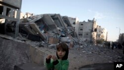 Umwana w'umunyepalistina ari ibibomoke vy'inyubakwa ya televiziyo Al-Aqsa ya Hamas yasambuwe n'indege za Isirayeli ku wa mbere