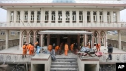 Petugas kota membersihkan masjid Baqir-ul Ulom di Kabul, Afghanistan pasca serangan bom bunuh diri hari Senin (21/11). 