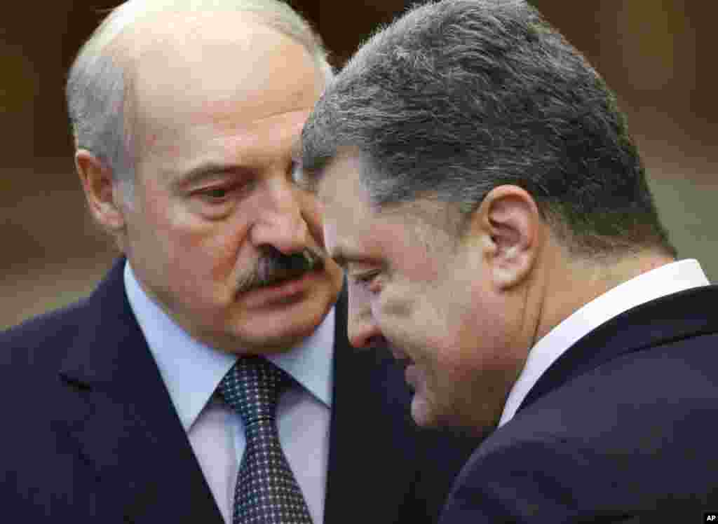Ukrainian President Petro Poroshenko, right, speaks with Belarus President Alexander Lukashenko after the peace talks in Minsk, Belarus, Feb. 12, 2015. 