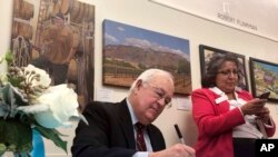 FILE - Former independent counsel Kenneth Starr signs a copy of his recent book "Contempt: A Memoir of the Clinton Investigation" at the University of New Mexico School of Law in Albuquerque, Jan. 23, 2019. 