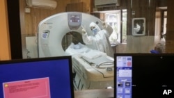 A medic wearing protective gear flashes victory sign while working in a ward dedicated for people infected with the new coronavirus, at Baqiyatallah Al'Azam Hospital affiliated to the Revolutionary Guard, in Tehran.