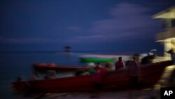 Miskito fishermen push a boat onto the shore on Savannah Cay, Honduras, at the end of a fishing trip, Sept. 10, 2018. Thousands of men across the Mosquitia region of Honduras and Nicaragua depend on lobster and sea cucumber fishing.